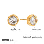 Gold earrings with clear gemstones on a white background Classic round cubic zirconia studs in yellow gold

