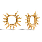 Gold sun-shaped earrings on a white background