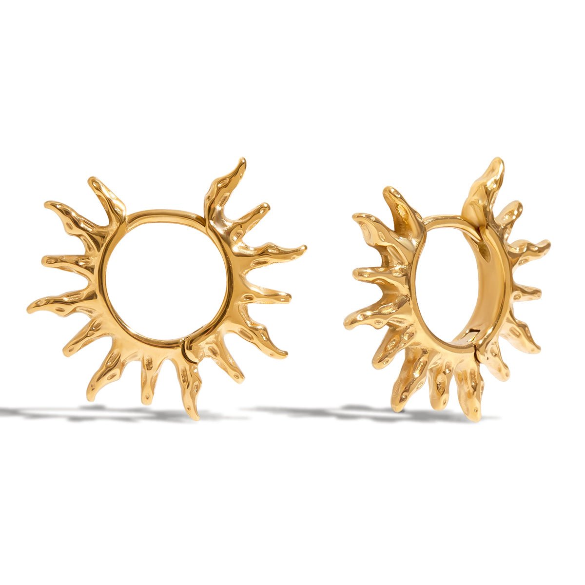 Gold sun-shaped earrings on a white background