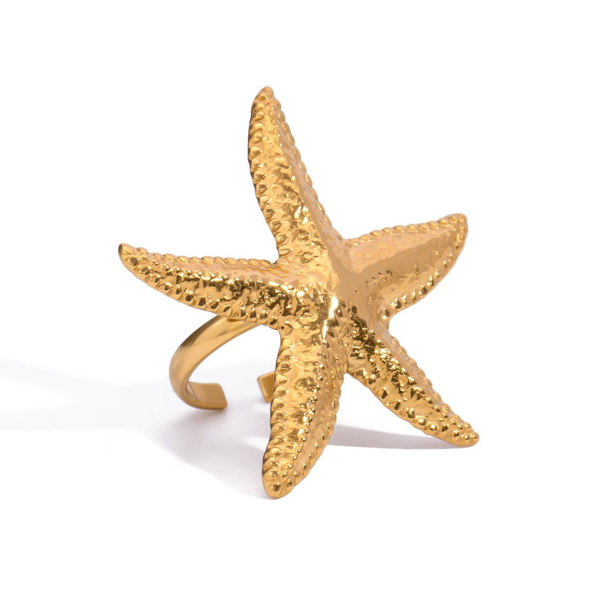 Gold starfish-shaped ring on a white background