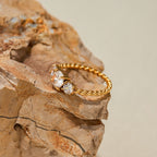 Gold ring with diamonds on a textured stone surface