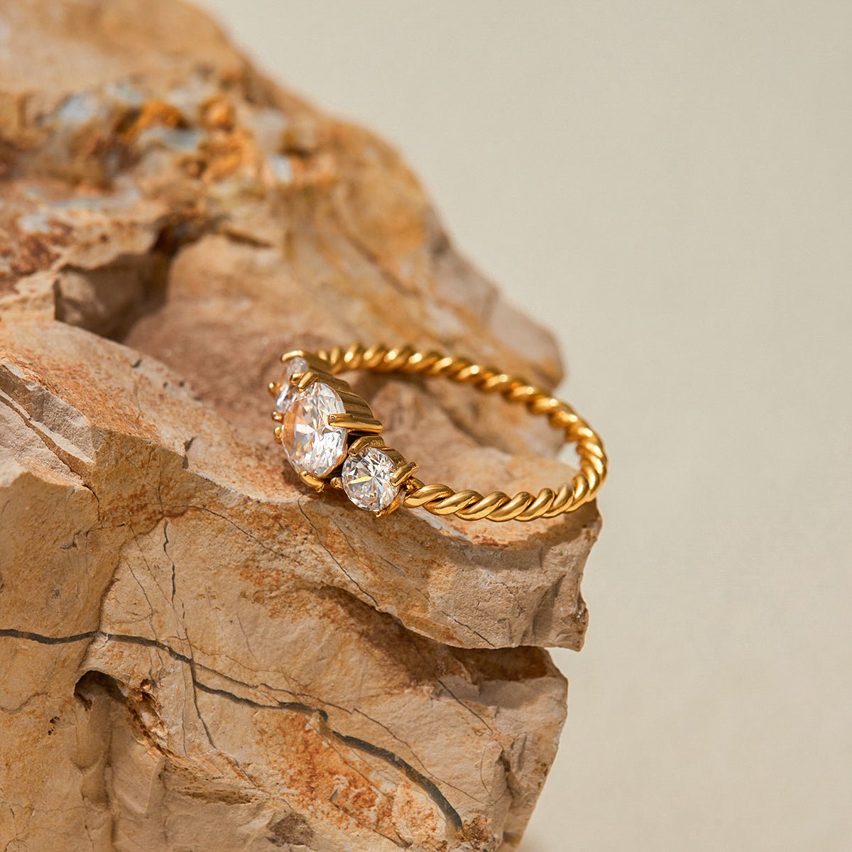Gold ring with diamonds on a textured stone surface