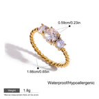 Gold ring with three clear gemstones, showing measurements and material details on a white background.