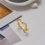 Gold ring on a light gray surface with a blurred background