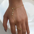 Gold bracelet and ring set on a hand against a white background