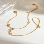 Minimalist Gold chain necklace with small crystals on a light background
