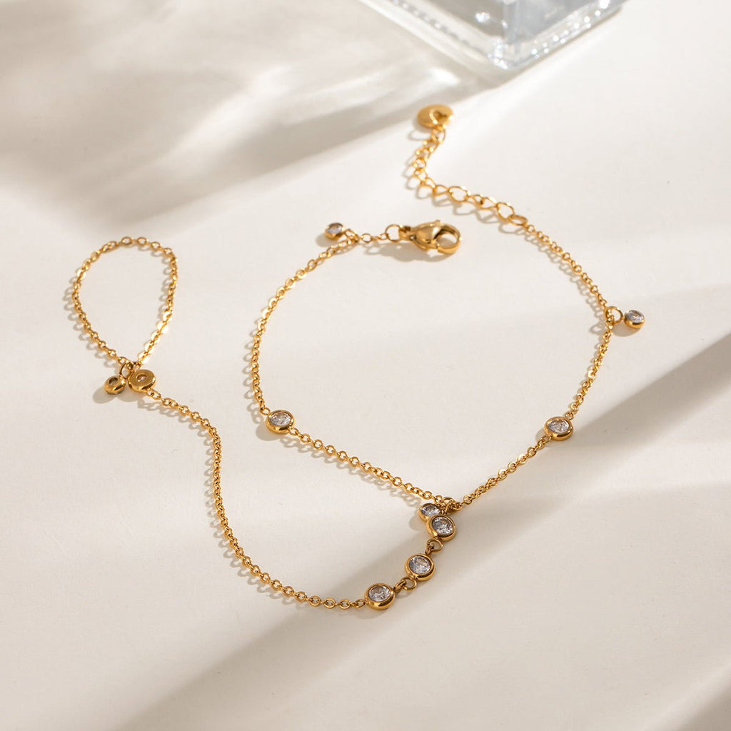 Gold hand chain bracelet with white stones