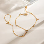 Gold hand chain bracelet with white stones