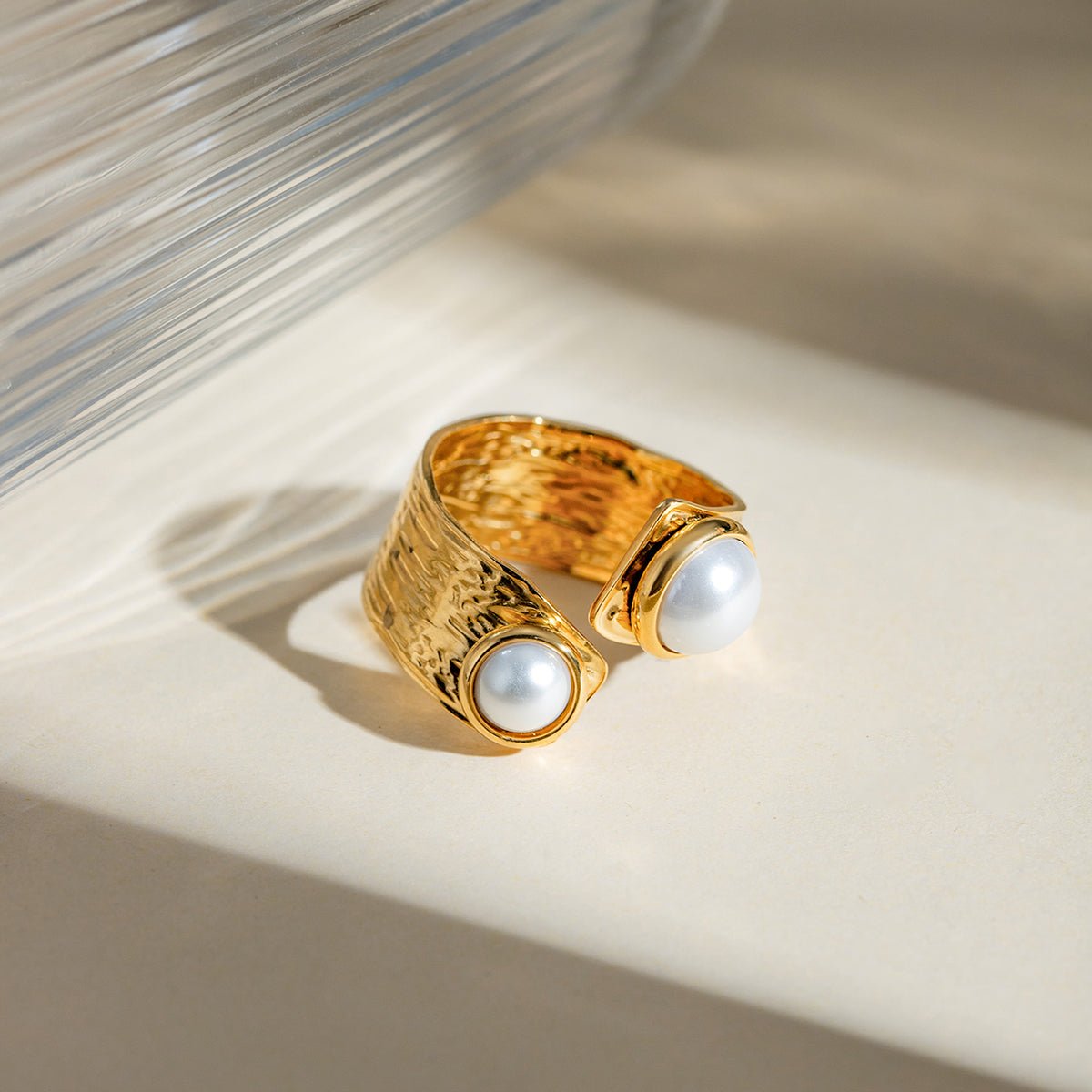 Gold ring with pearl stones on a textured surface