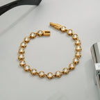 Gold bracelet with diamond accents on a white surface