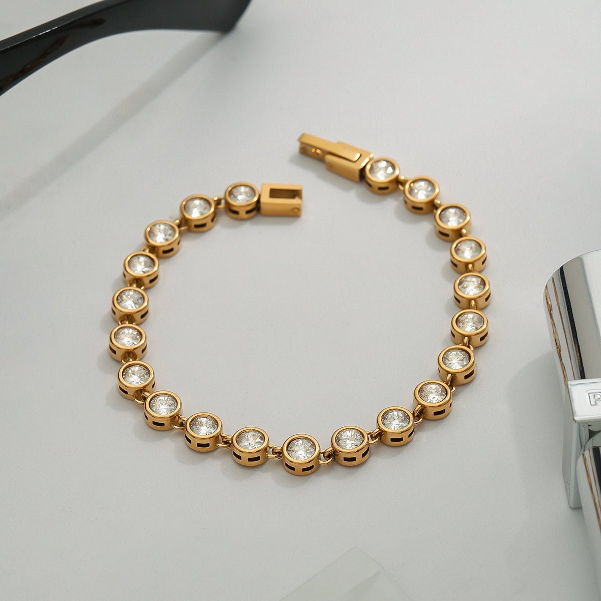 Gold bracelet with diamond accents on a white surface