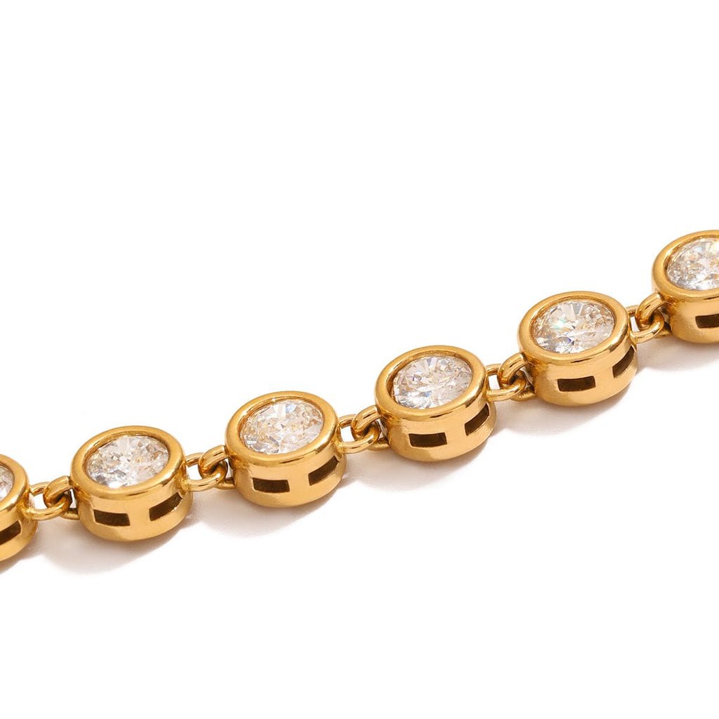 Gold bracelet with diamond-like stones on a white background