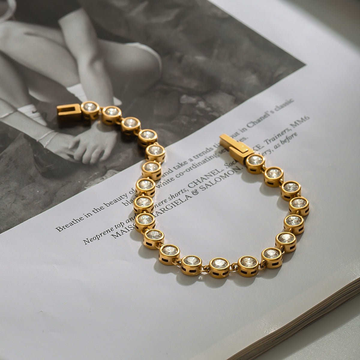 Gold bracelet with clear stones on a book