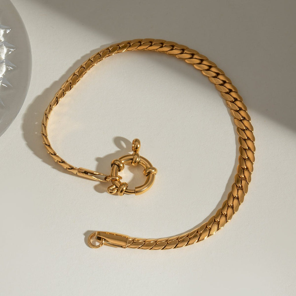 Gold chain bracelet on a light background