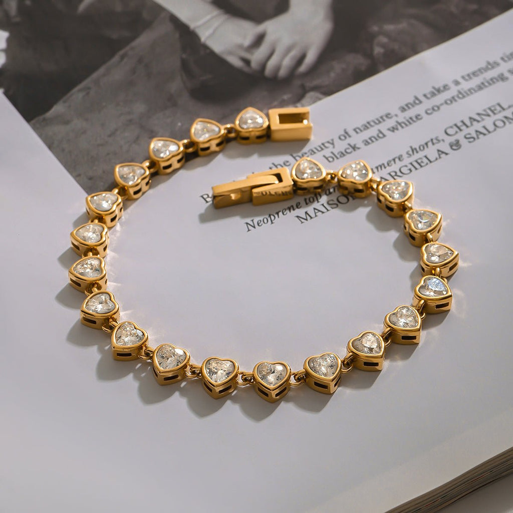 Gold bracelet with heart-shaped gemstones on a magazine page