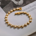 Gold bracelet with heart-shaped gemstones on a magazine page