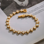 Gold bracelet with heart-shaped gemstones on a magazine page