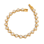 Gold bracelet with heart-shaped diamond accents on a white background