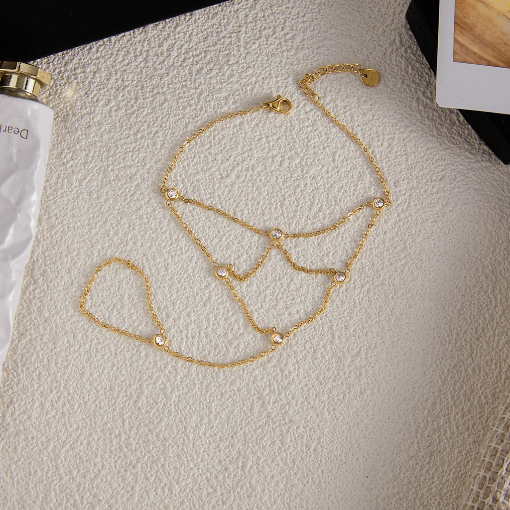 Gold chain bracelet on a mannequin bust against a neutral background