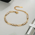 Gold bracelet with crystal accents on a light gray surface
