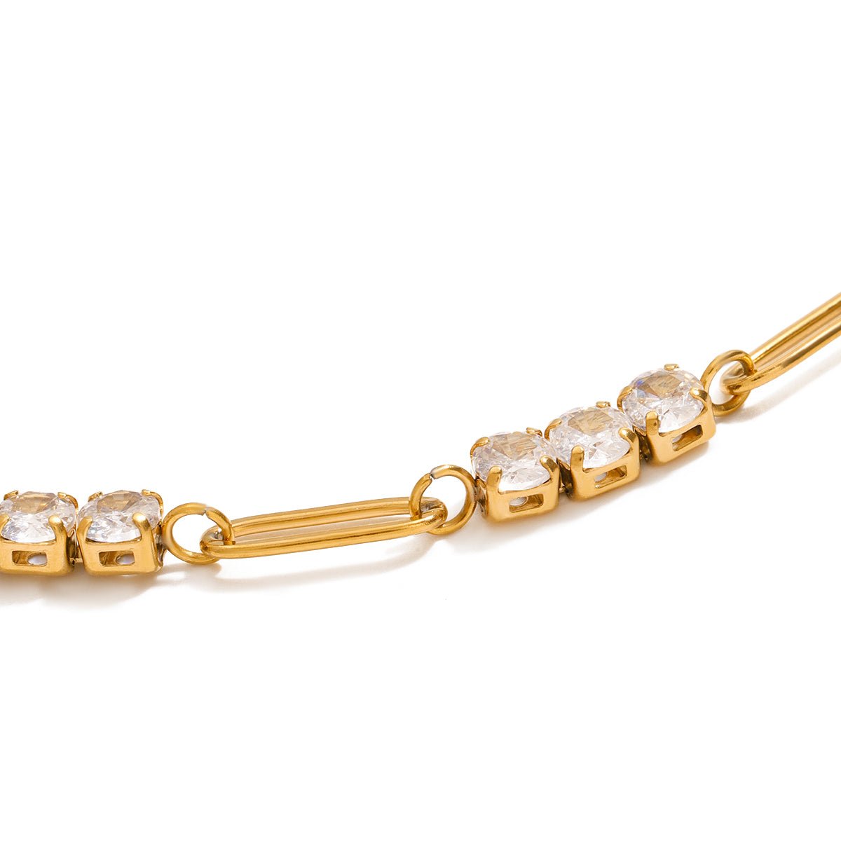 Gold bracelet with clear gemstones on a white background