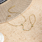 Gold Bracelet with turquoise stones on a textured beige surface