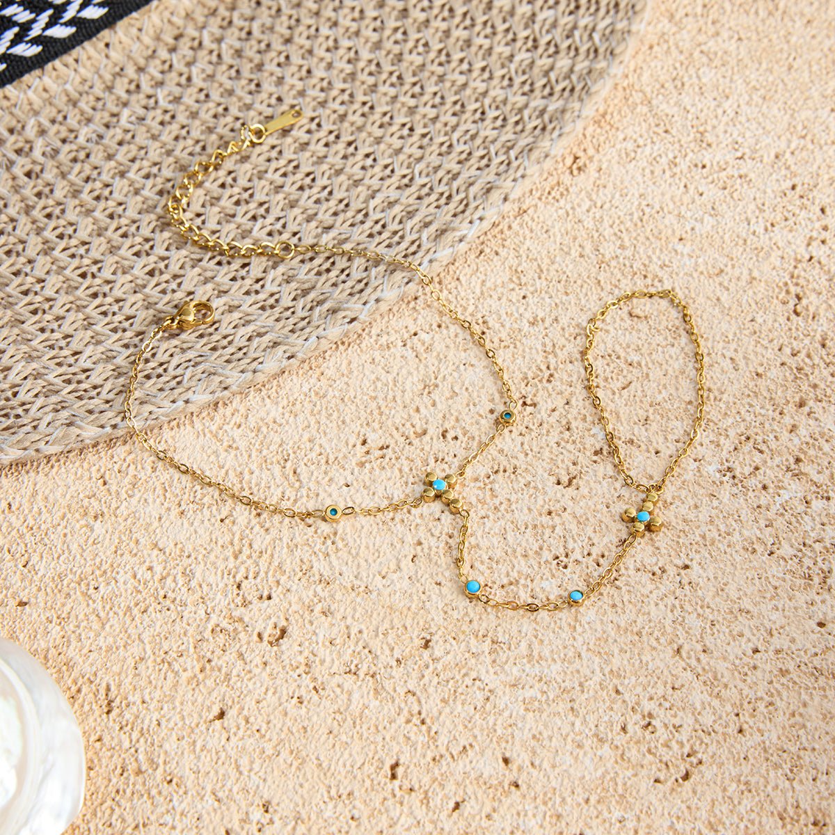 Gold Bracelet with turquoise stones on a textured beige surface