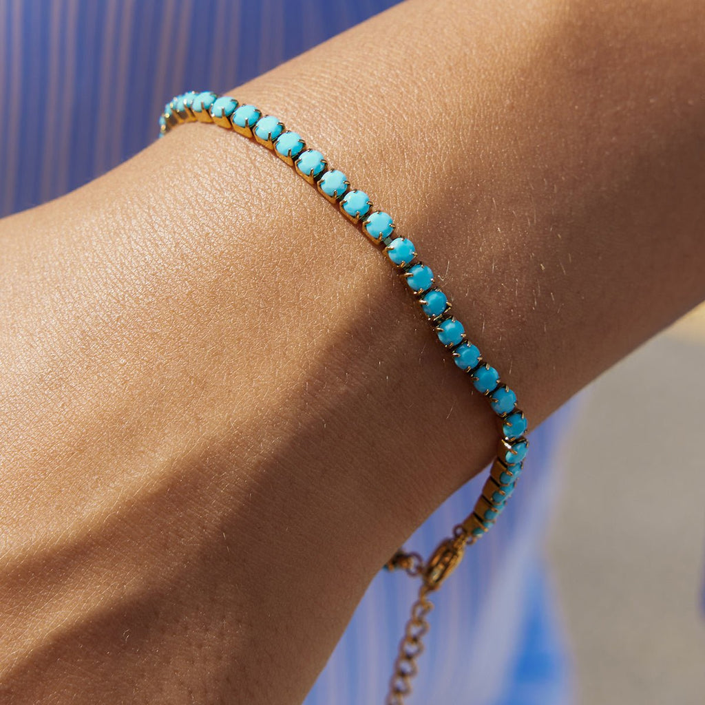 Turquoise beaded bracelet on a wrist with a blurred background