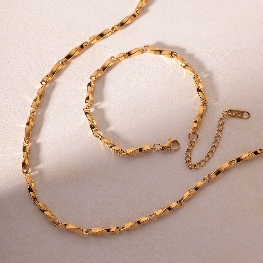 Gold chain necklace on a light beige background