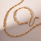 Gold chain necklace on a light beige background