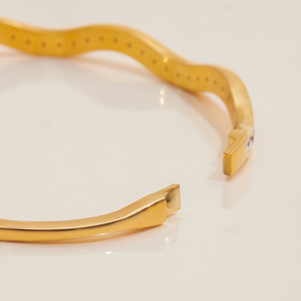 Gold bracelet on a light beige background