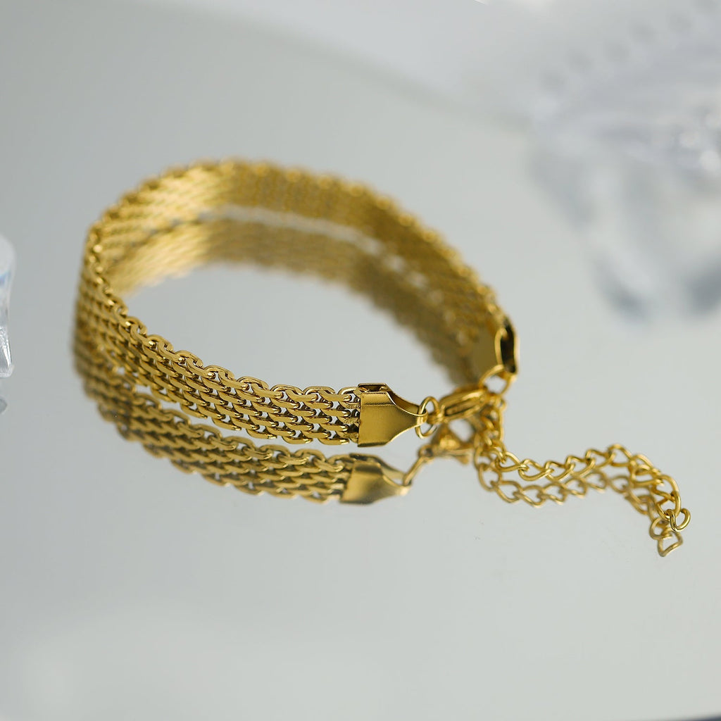 Gold chain bracelet on a light gray background