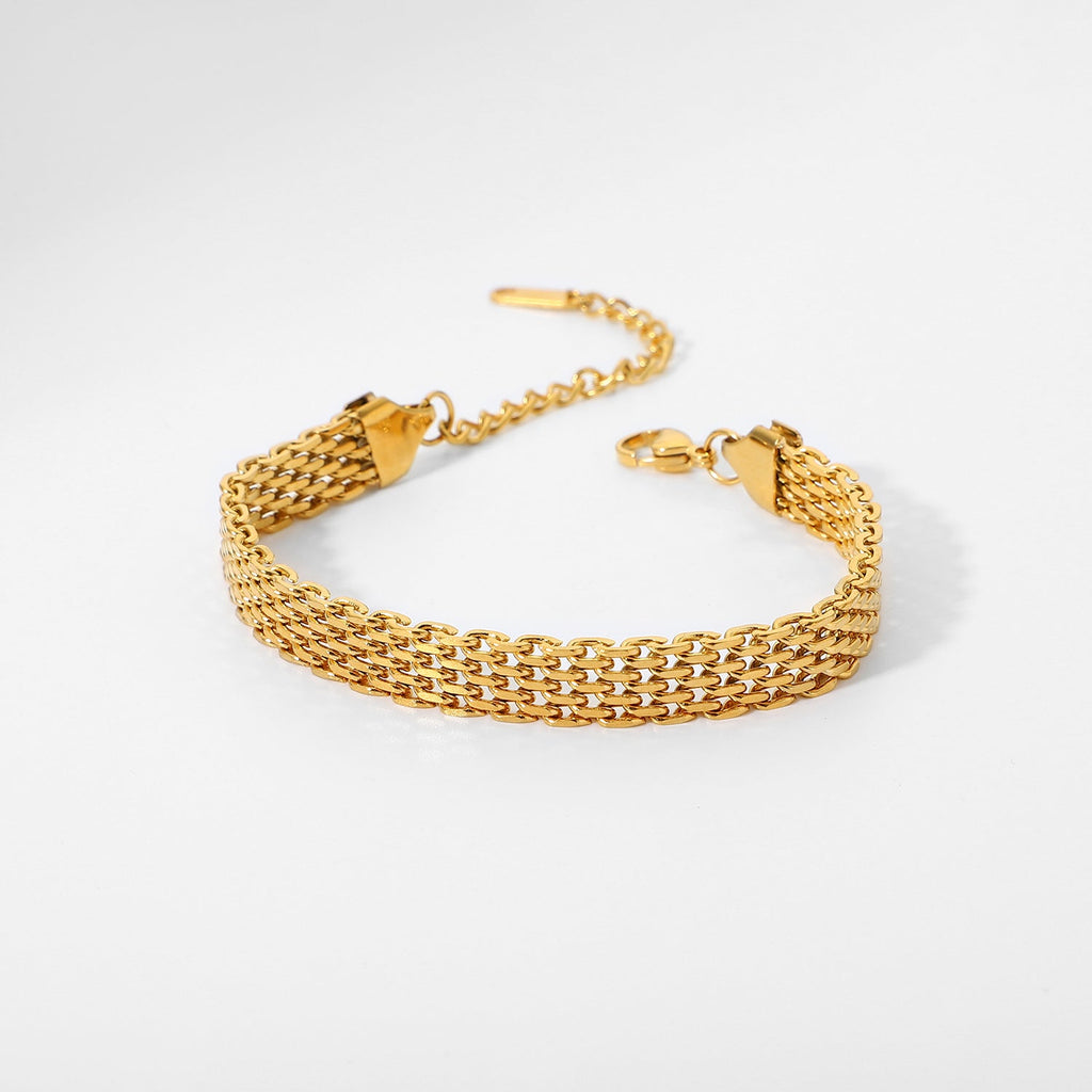 Gold chain bracelet on a light gray background