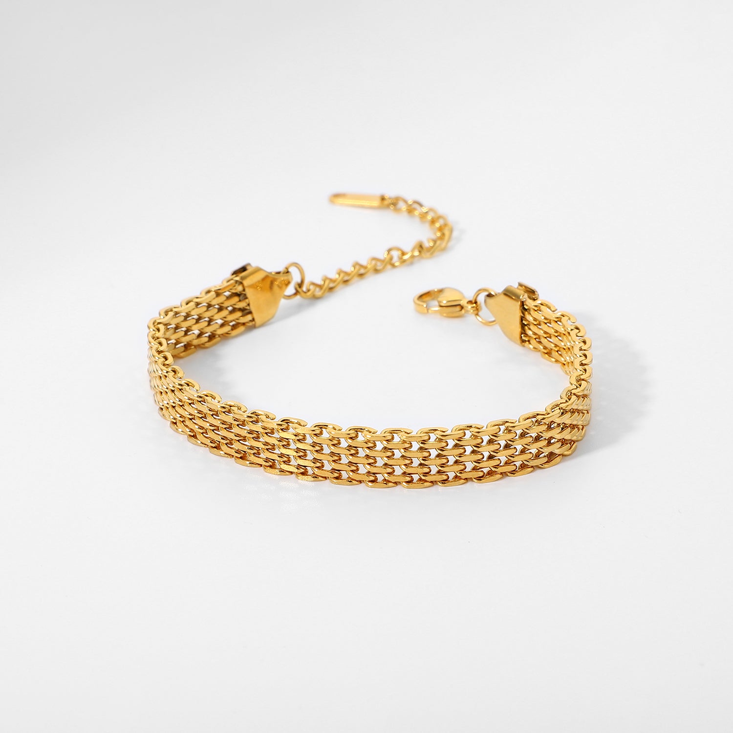 Gold chain bracelet on a light gray background