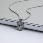 Silver pendant necklace on a light gray background