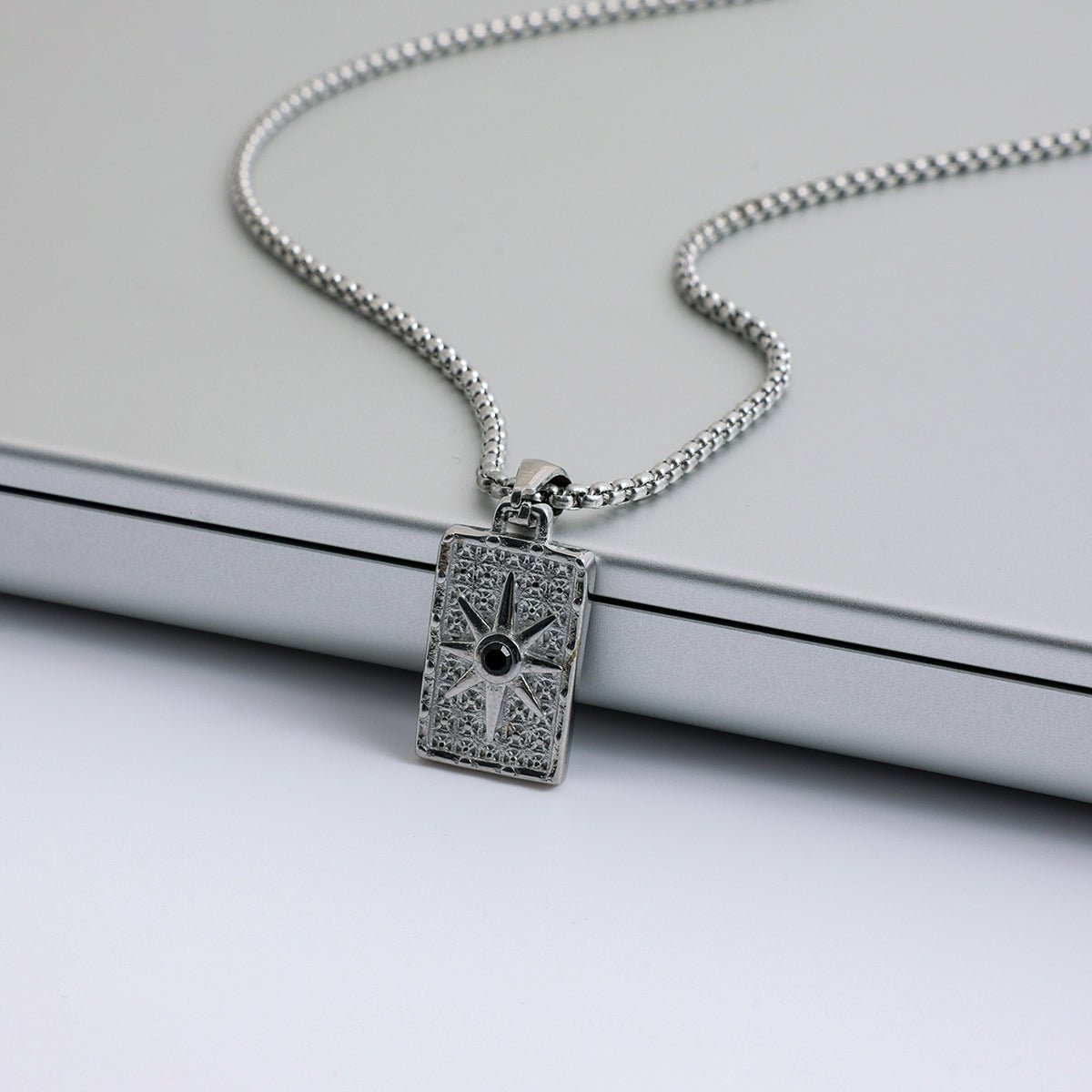 Silver pendant necklace on a light gray background