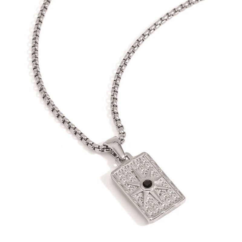 Silver pendant necklace with intricate design on a white background