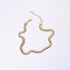 Gold snake chain necklace on a light gray background