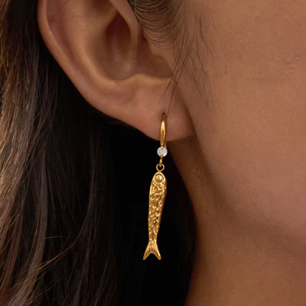 Very Fishy Indeed earrings featuring 18k gold PVD plated textured fish charms.