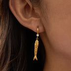 Very Fishy Indeed earrings featuring 18k gold PVD plated textured fish charms.
