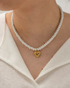 The Pearl Strand necklace featuring 18k gold PVD plated heart pendant and pearls.