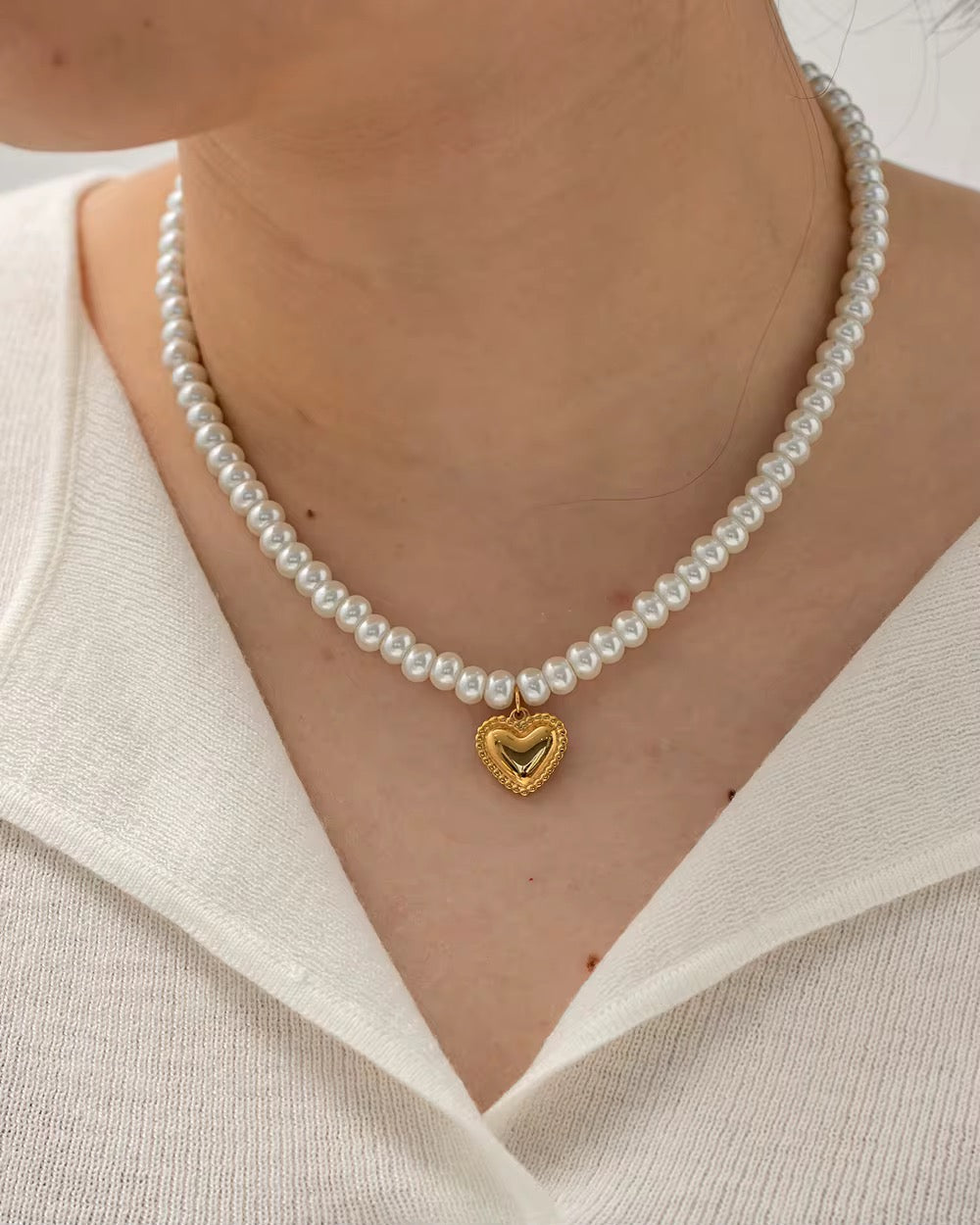 The Pearl Strand necklace featuring 18k gold PVD plated heart pendant and pearls.