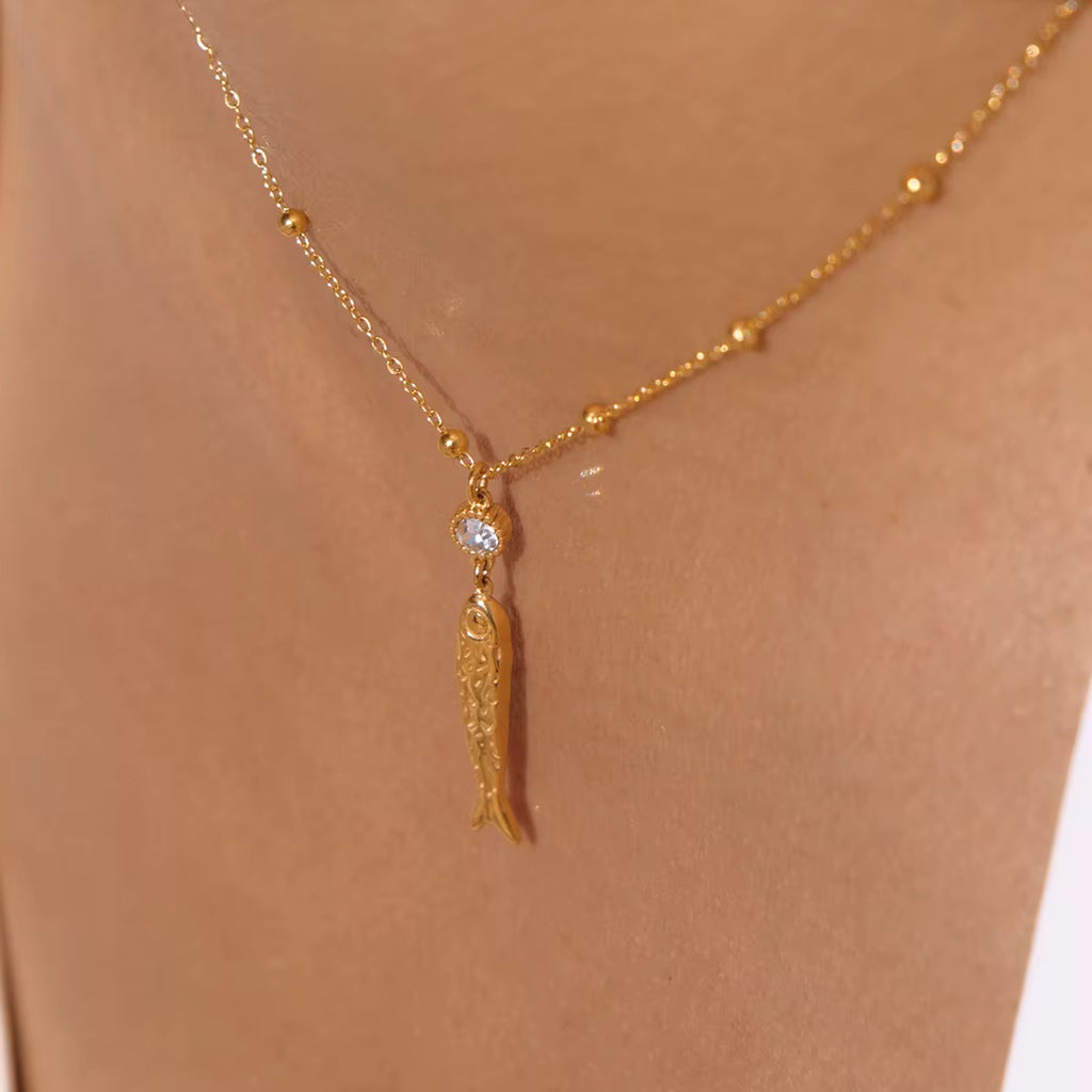 Waterproof Very Fishy Indeed gold necklace featuring a crystal-accented fish charm.
