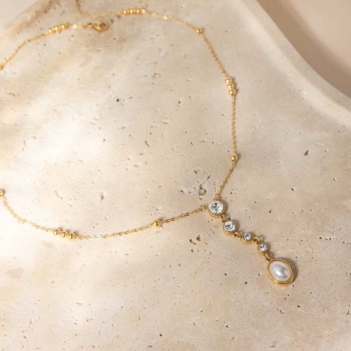 Waterproof gold lariat necklace with mixed-cut geometric crystals for swimming and active wear.