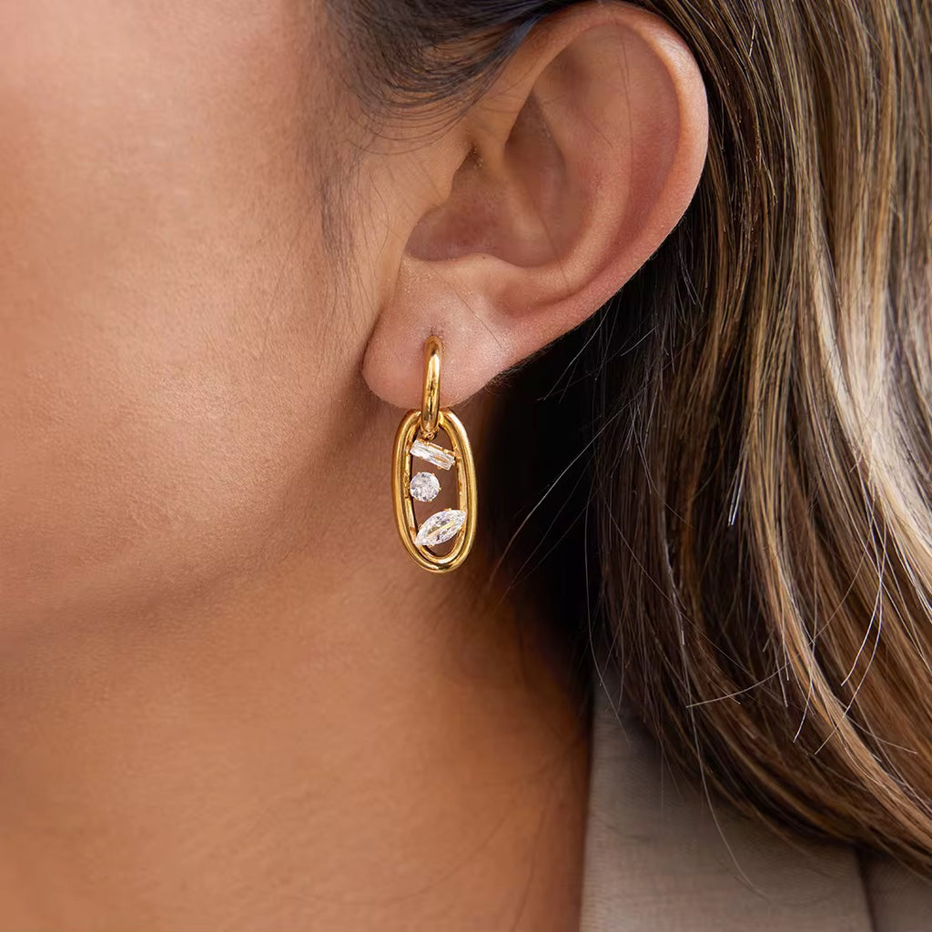 Waterproof gold huggie earrings with an elongated oval drop link for swimming.