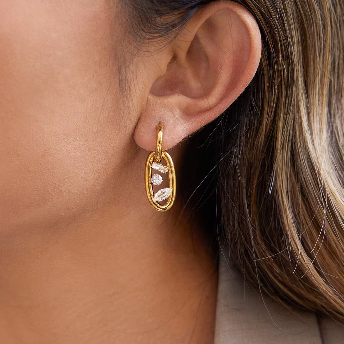 Waterproof gold huggie earrings with an elongated oval drop link for swimming.