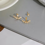 Waterproof gold ear jacket earrings with a seven-stone crystal arc for swimming.