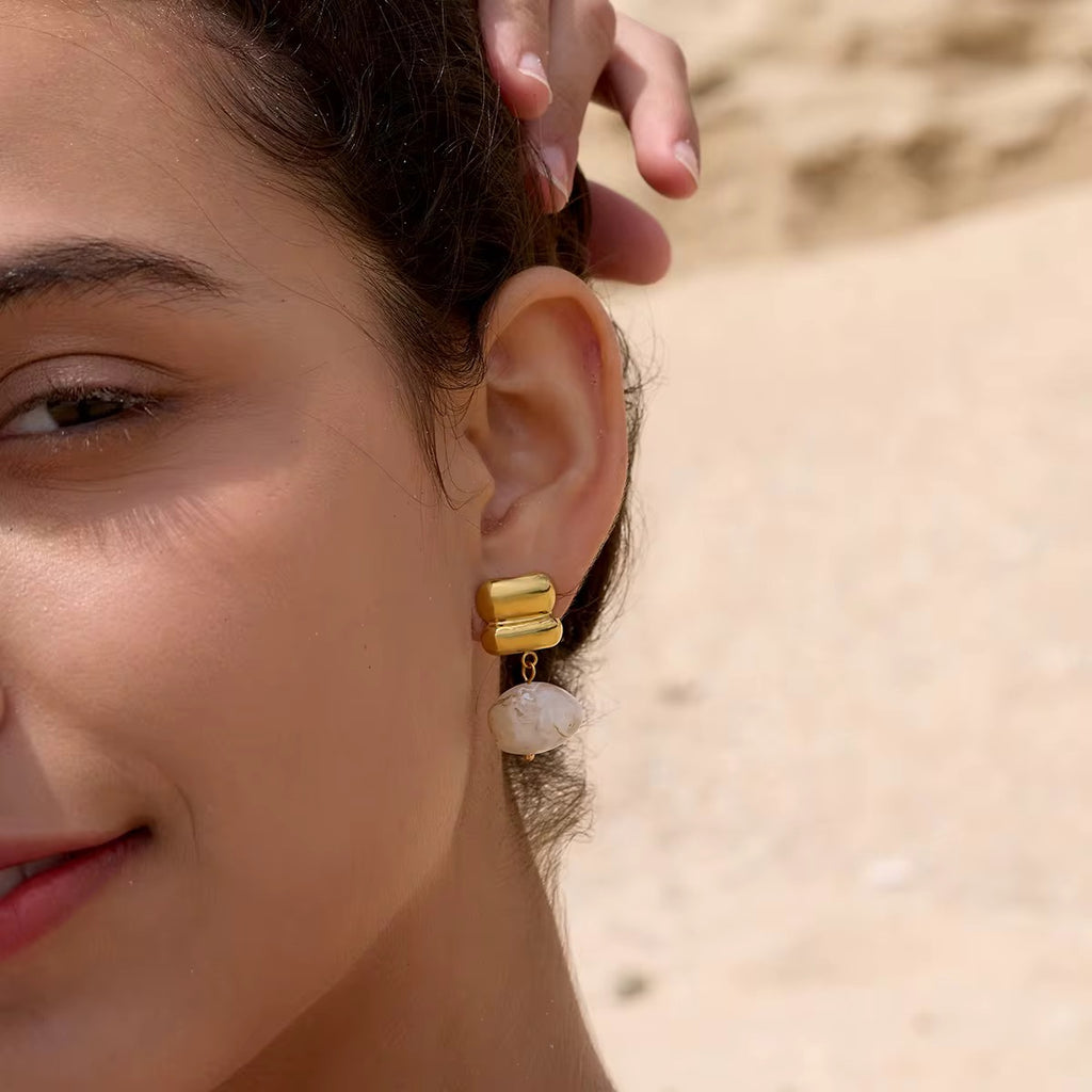 Detail of the polished double-pillow gold stud on an Amber Solstice drop earring.