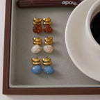 Amber Solstice drop earrings featuring 18k gold PVD plating and red agate stones.
