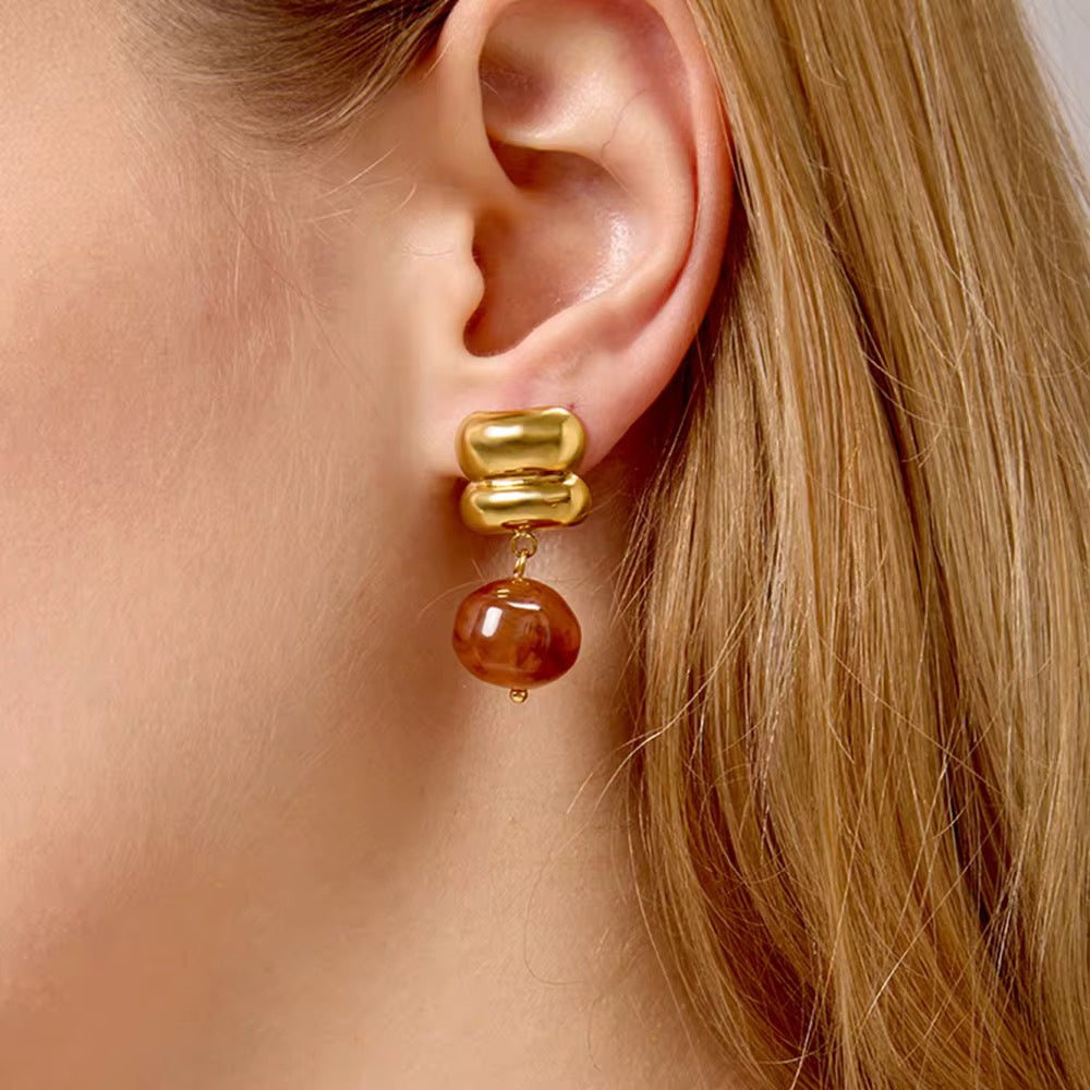 Detail of the marbled brown and red red agate stone on an 18k gold statement earring.